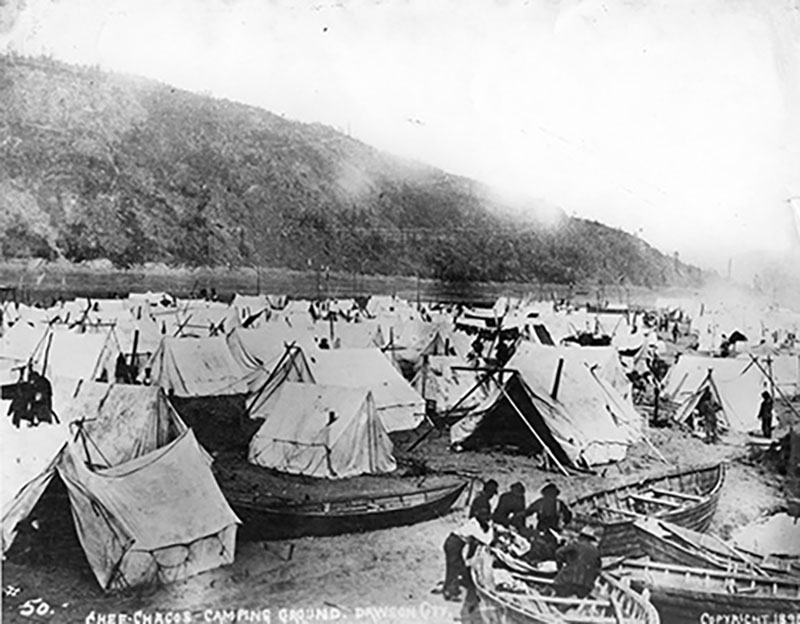 Un grand nombre de tentes installées au pied d’une montagne.