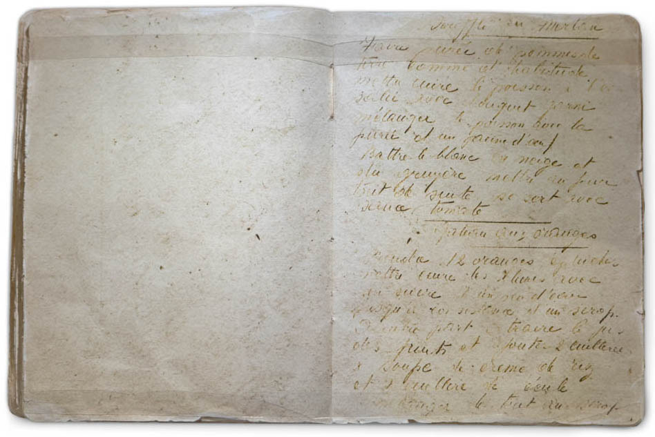 Un vieux livre, ouvert sur une page manuscrite, difficilement déchiffrable, en français.