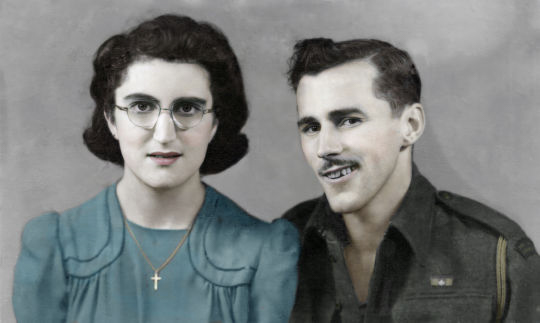 Photo en noir et blanc de Marjorie et de Frank Englehart dans leur jeunesse, colorisée pour rendre la robe de la femme bleu clair et ses lèvres roses. Elle porte des lunettes et une croix sur son collier. Il porte la moustache et un uniforme militaire dont les premiers boutons sont défaits.