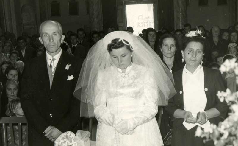 Photographie de Maria Disipio (née Stenta) le jour de son mariage. Elle s’est mariée à Casacanditella, dans la région italienne des Abruzzes, au mois d’octobre 1953. Son père Giuseppe, une dame d’honneur et sa mère Carolina se trouvent derrière elle, à gauche. Musée canadien de l’immigration du Quai 21 (DI2013.1901.3)