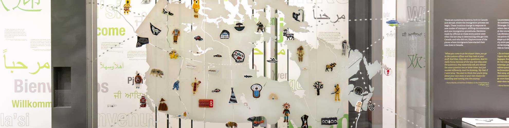 Une grande carte de l’Île de la Tortue sur un mur en verre, arborant plusieurs œuvres d’art autochtone en verre.