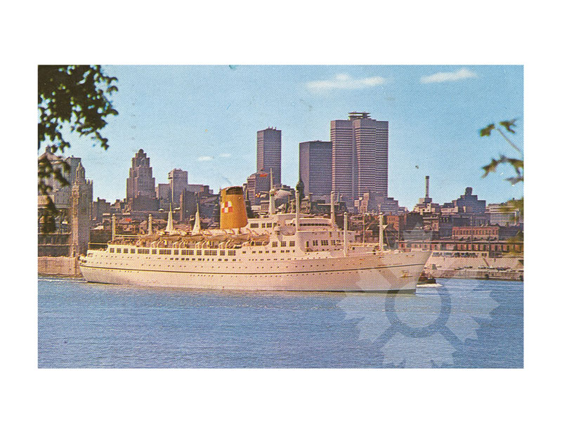 Photographie en couleur du RMS Empress of Britain amarré dans un port, vu de profil bâbord, avec la silhouette de la ville en arrière-plan.