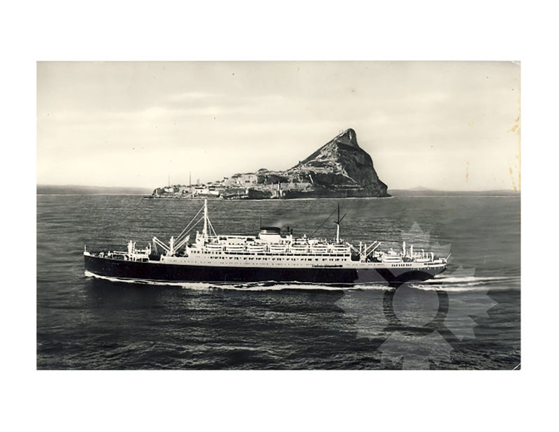 Image en noir et blanc du MS Vulcania en mer, vu de profil bâbord, avec le rocher de Gibraltar en arrière-plan.