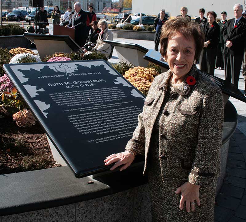 Une femme se tient devant une plaque de marbre.
