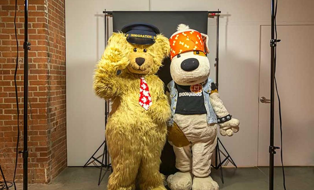Deux adultes vêtus de costumes d’ours et de mascotte de chien.