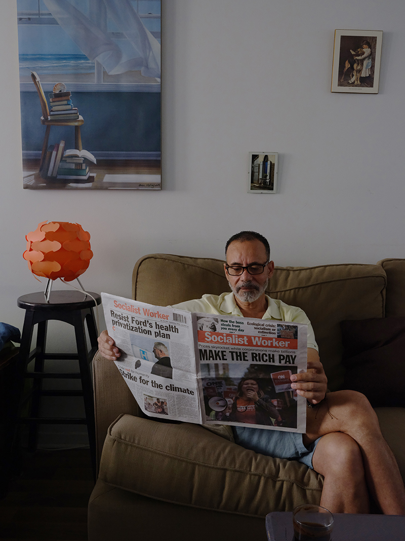 Un homme est assis sur un canapé à lire un journal.