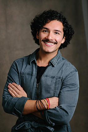 Portrait de Santiago Guzmán souriant à l’appareil photo, les bras croisés.