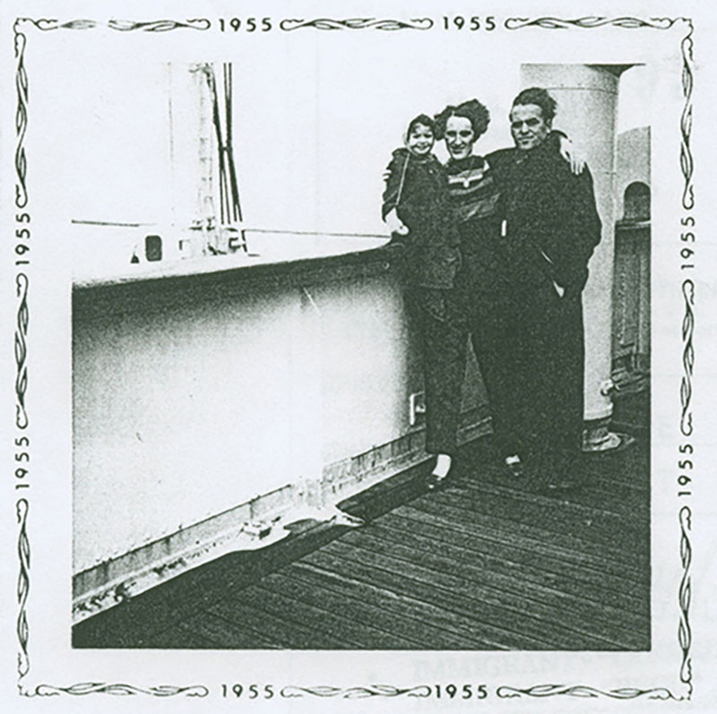 Photo d'archive datant de 1955. Elle montre le pont d'un navire sur lequel se trouve une femme, un homme et un enfant. La femme est au centre et ses bras entourent l'enfant et l'homme.