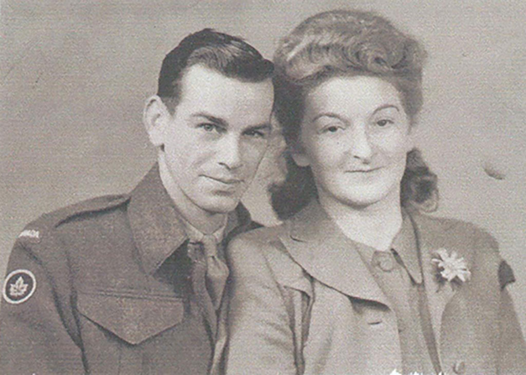 Un vieux portrait montrant un jeune homme en uniforme. Il se penche en direction d'une jeune femme qui porte un bel habit et qui a une fleur à sa boutonnière.