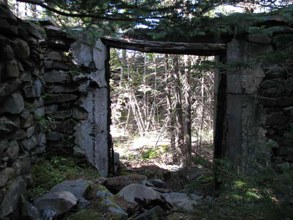 Vue d’une porte d’un vieux bâtiment en pierre abandonné.