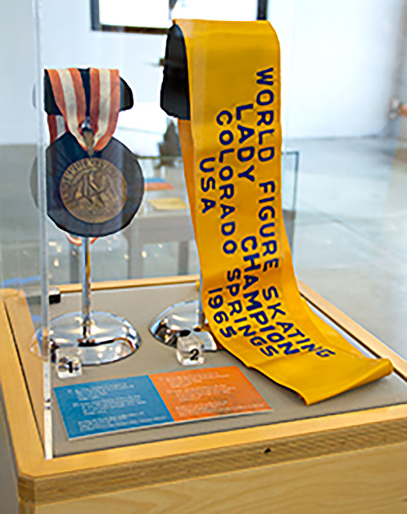Une médaille de bronze des Olympiques dans une vitrine en verre; elle fait partie d’une exposition de musée.