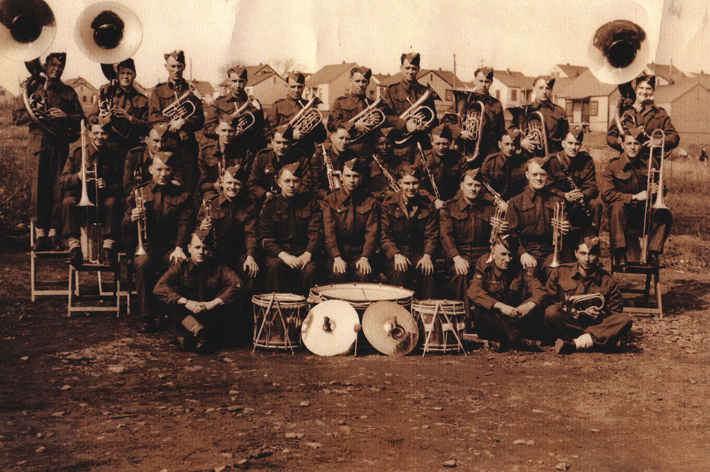Portrait sépia d’un grand orchestre militaire. Certains hommes sont assis et d’autres sont debout.