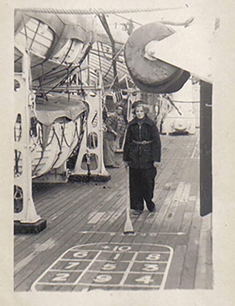 Une photo d'archive montrant une jeune femme vêtue de noir qui joue au jeu de galets sur le pont d'un navire.
