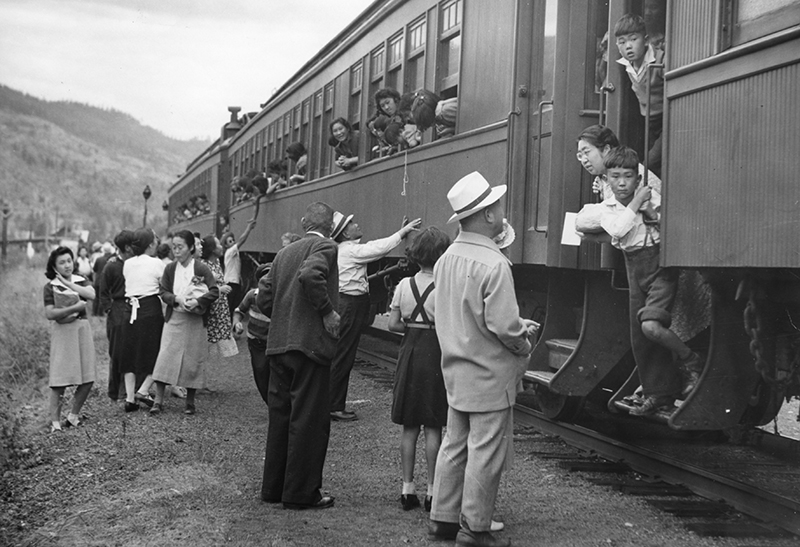 Image d’archives montrant plusieurs personnes au sol à l’extérieur d’un train, tandis que les gens dans le train regardent par les fenêtres.