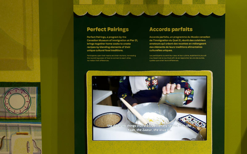 Un mur vert présentant une vidéo d’une femme en train de cuisiner, avec un texte expliquant le programme Accords parfaits du Musée.