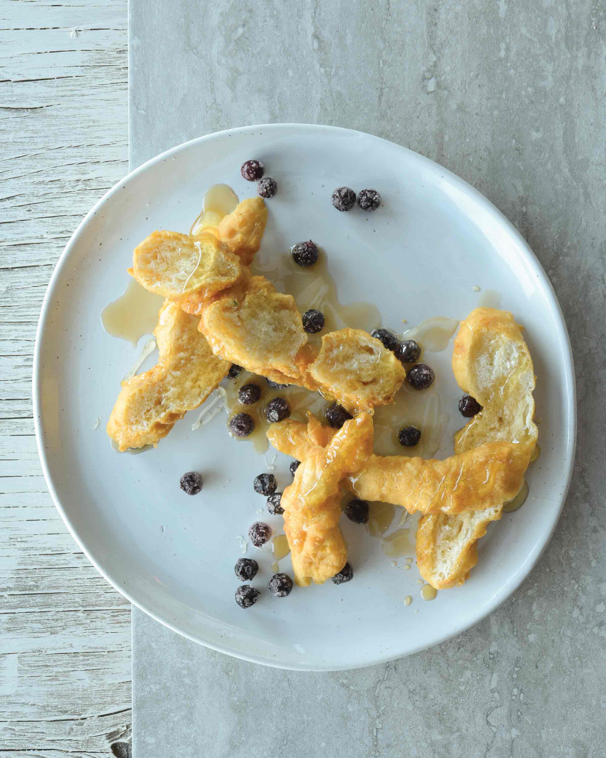 Bannock sur une assiette blanche, garni de baies et de sirop.