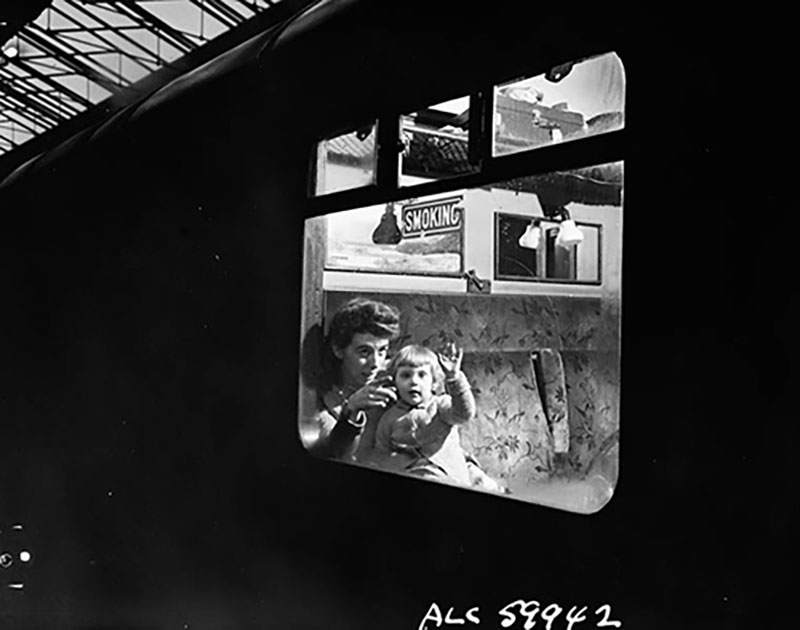 Une femme et son petit enfant regardent par la fenêtre d’un train.