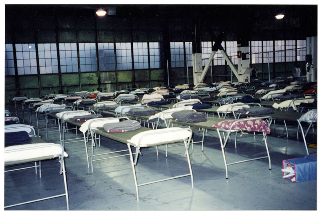 Un entrepôt rempli de lits de camp.