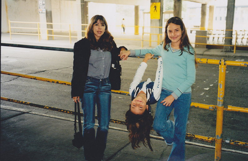 Photographie de Monica Valencia avec sa mère et sa sœur à l'aéroport métropolitain de Detroit, 2002. 