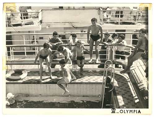 Plusieurs jeunes garçons sautent dans une piscine à bord d’un navire.