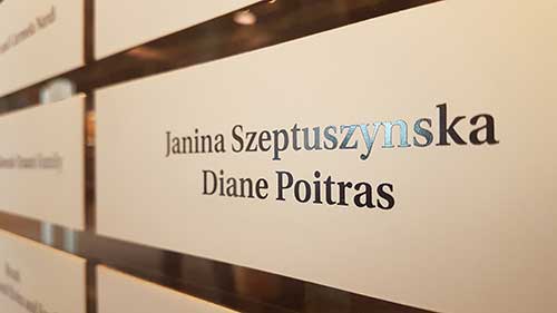 Une plaque argentée sur fond de brique sur laquelle il est écrit Diane Poitras Janina Szeptuszynska.