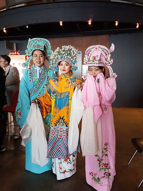 Trois jeunes filles vêtues de costumes traditionnels célèbrent le Nouvel An lunaire.