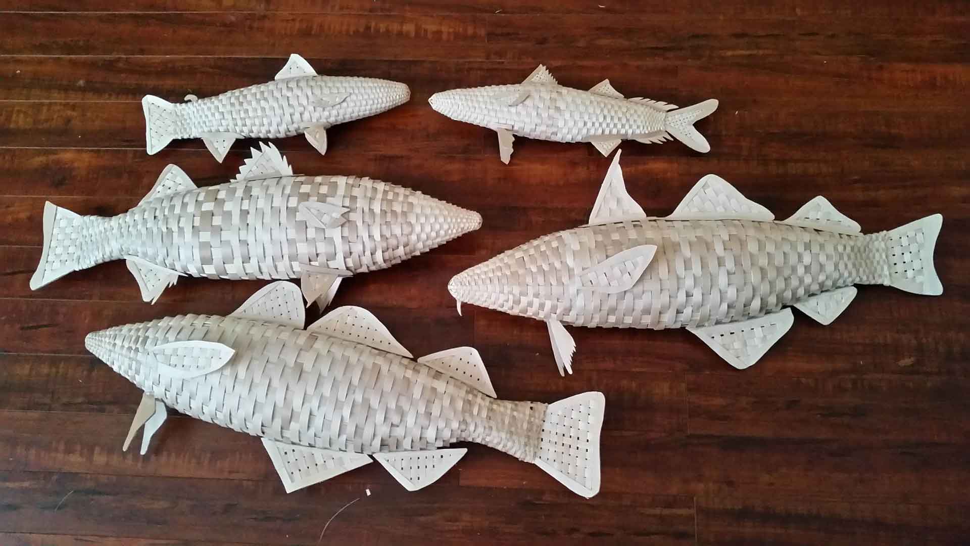 Plusieurs espèces de poissons tissées à partir de lamelles de bois.