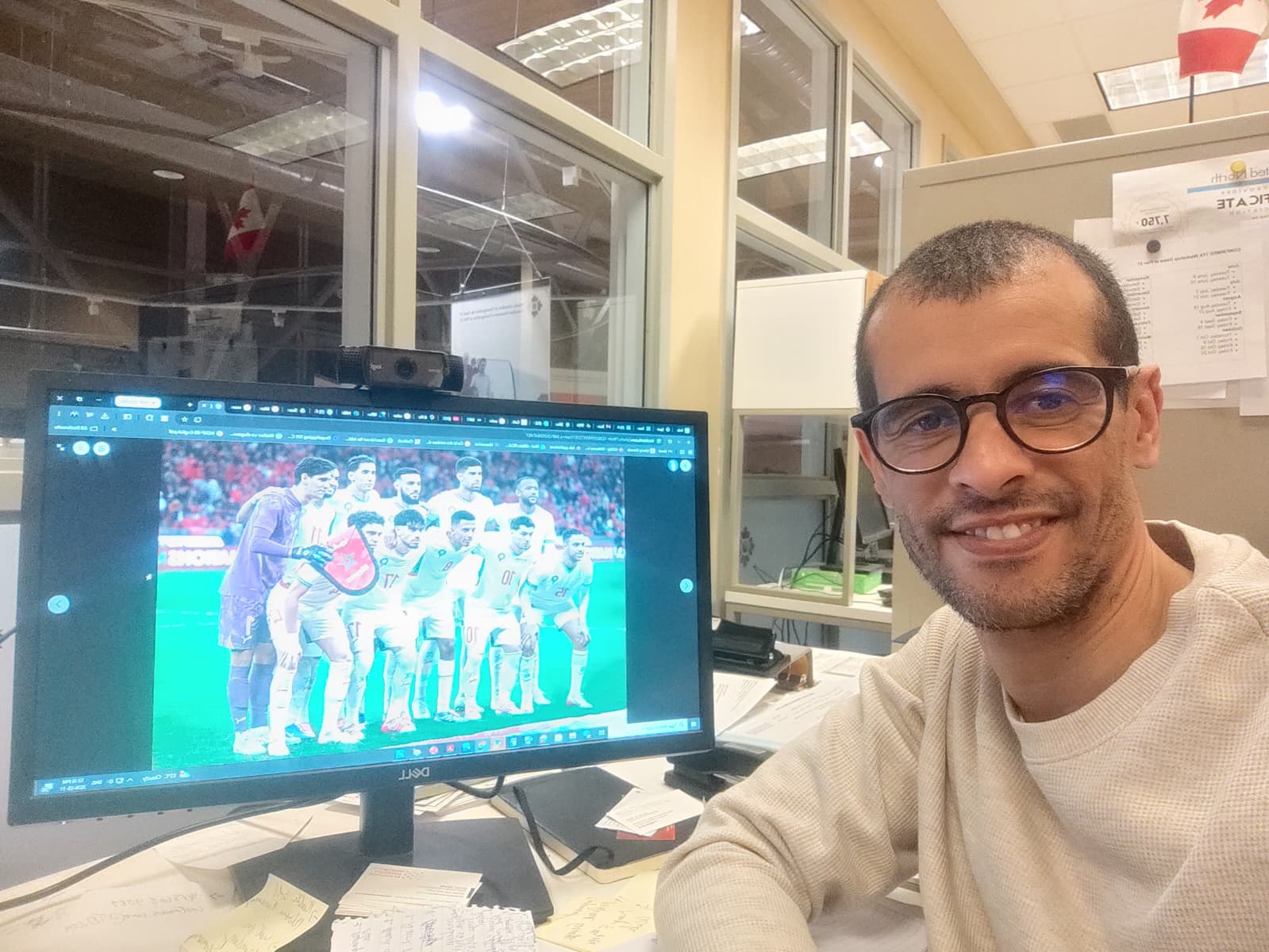 Saïd, à son bureau, avec une photo de l’équipe nationale marocaine de soccer sur son écran.