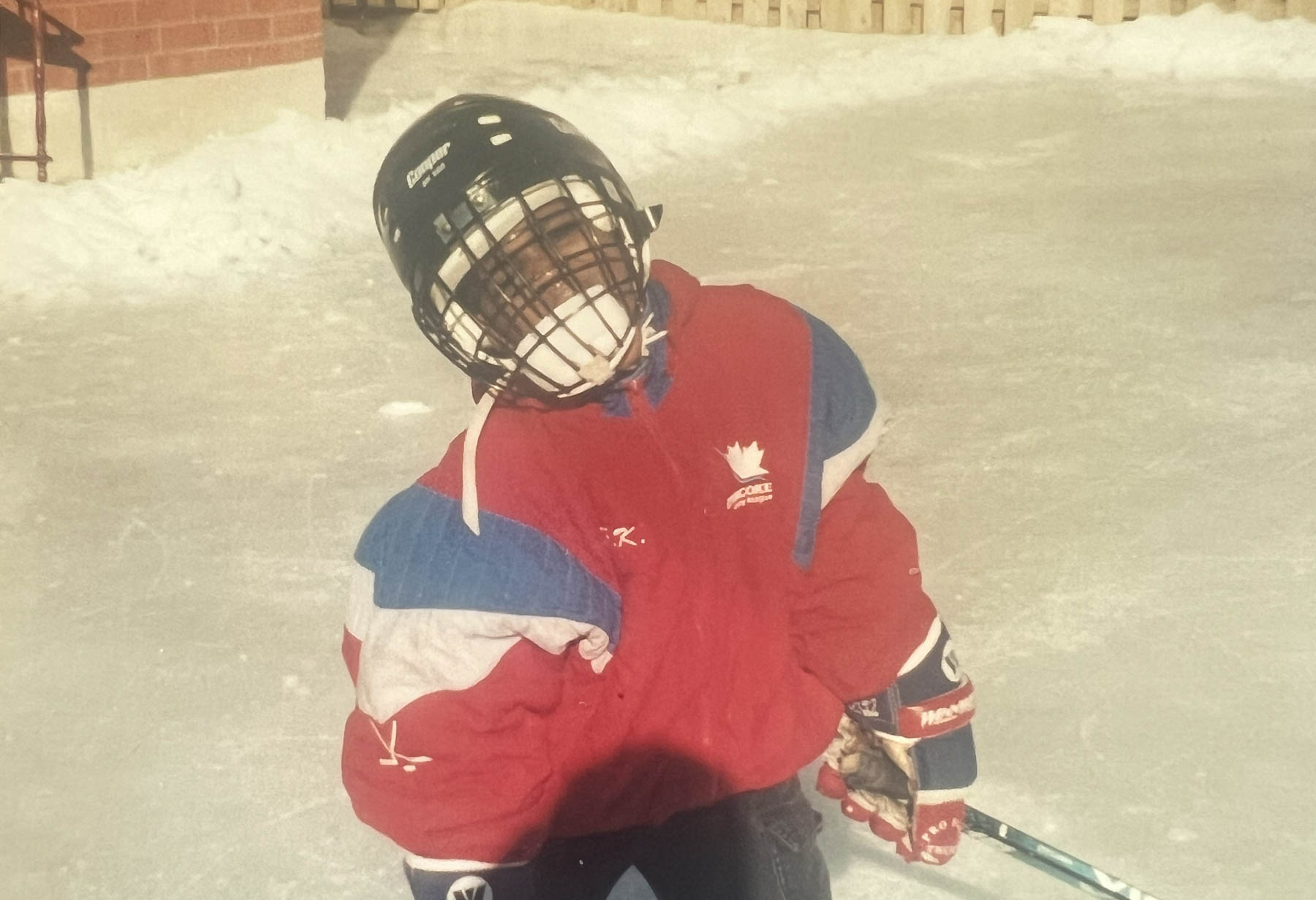 Un garçon noir d’une dizaine d’années, en habit de hockey.
