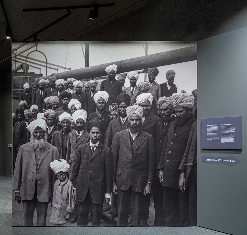Sur un mur du Musée, un grand tirage d’une photo en noir et blanc montre une trentaine d’hommes et d’un petit garçon en turbans à bord d’un navire. Tous regardent la caméra.