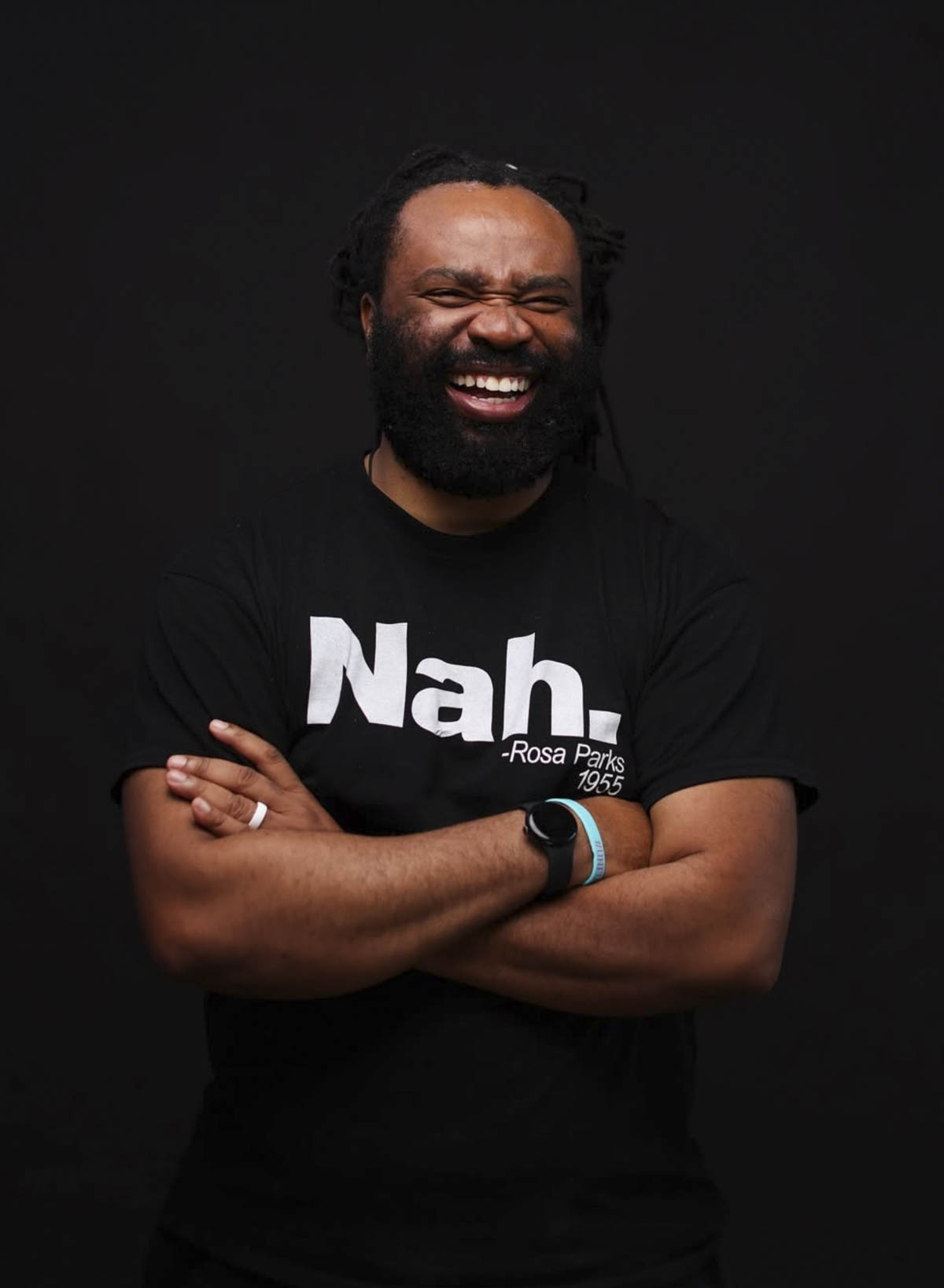 Un homme noir barbu au sourire radieux.