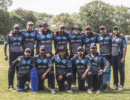 Photo d'équipe de deux rangées de joueurs de cricket portant des chandails bleus avec l'inscription Nouvelle-Écosse à l'avant.