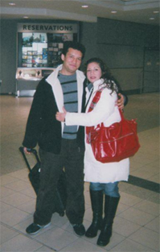 Un homme et une femme s’enlacent à l’aéroport.