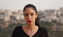 Portrait de Rana Nazzal Hamadeh sur un fond extérieur flou, portant une queue de cheval et un rouge à lèvres rouge.