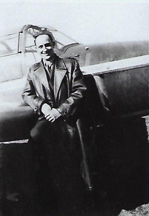 Photographie en noir et blanc d'un jeune homme appuyé contre la cabine d'un petit avion.