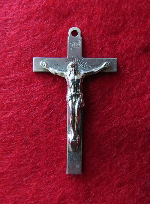 Une croix religieuse avec Jésus-Christ sur fond rouge.