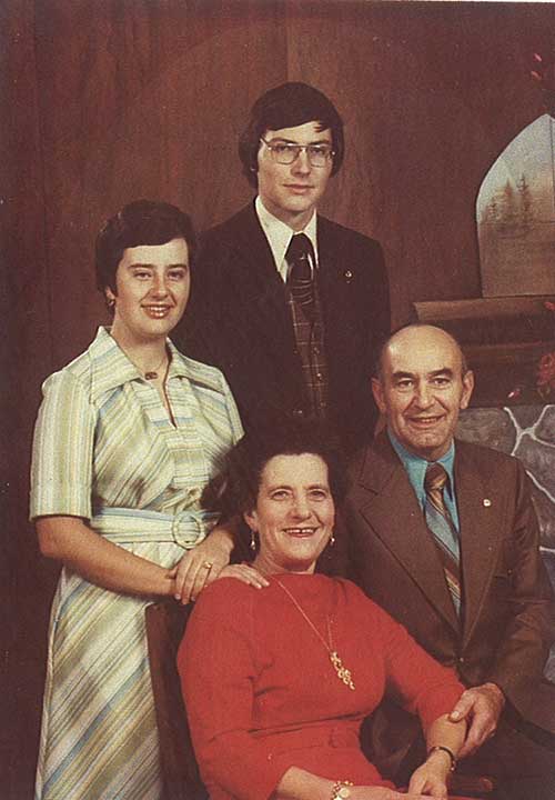 Une famille bien habillée pose pour une photo.
