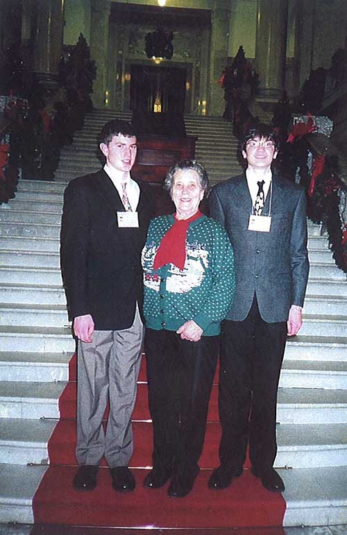 Belle femme avec deux jeunes garçons debout côte à côte sur les escaliers.