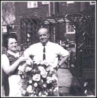 Homme et femme à l’extérieur de la maison avec des fleurs.