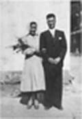 Vieille photographie montrant deux époux le jour du mariage, la mariée tenant des fleurs.
