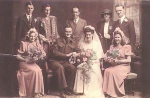 Jeunes époux, entourés par le cortège nuptial et les membres de la famille.