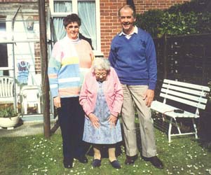 Audrey plus âgée, avec son frère et sa vieille mère dans le jardin derrière la maison. 