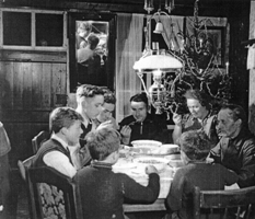Photographie spontanée de plusieurs membres de la famille assis dans la cuisine.