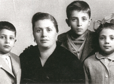 Portrait de famille montrant une femme entourée par deux petits garçons et une fille.
