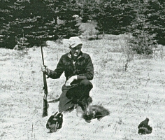 Le jeune Cornelius à genoux, tenant une arme avec 2 corbeaux morts et un lapin au sol.