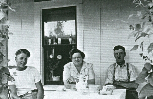 Le jeune Cornelius et le couple plus âgé assis à table sur le porche de la maison.