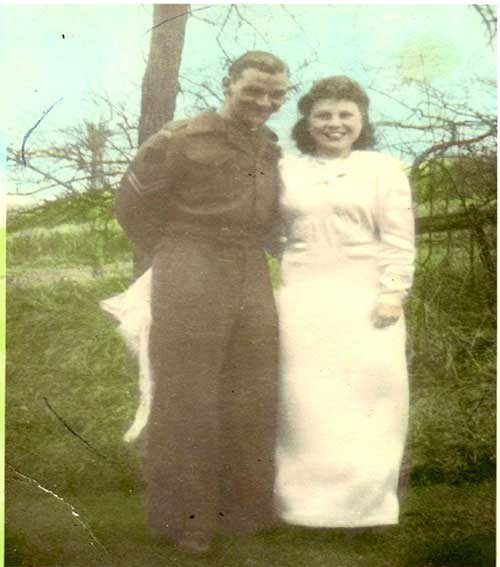 Un jeune homme et une jeune femme se tiennent devant un arbre.