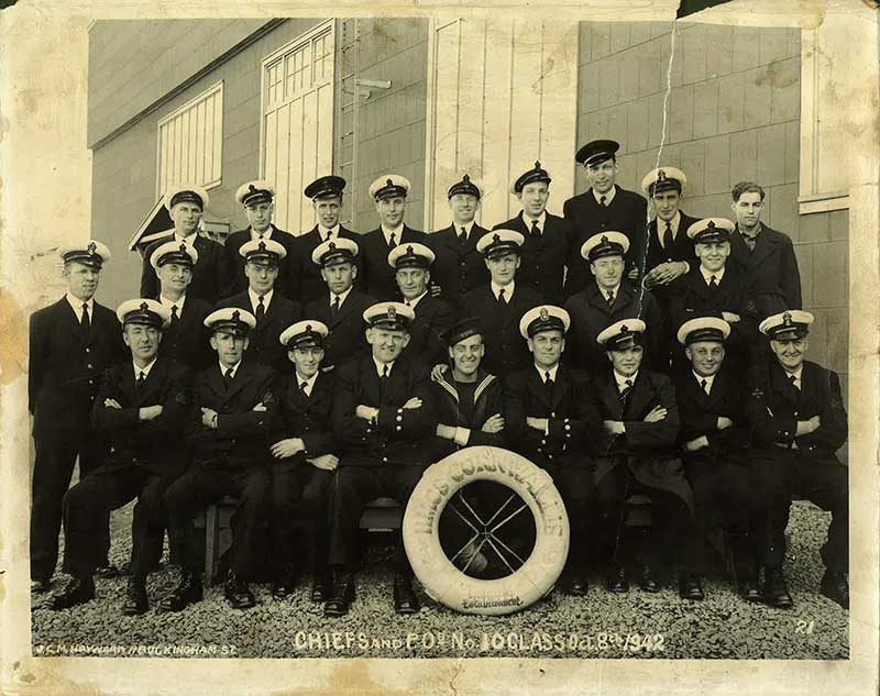 Des marins et des officiers en uniforme. Ils sont assis et posent pour la photo.