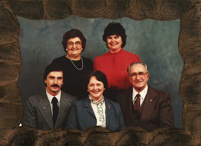 Un portrait de famille montrant un homme, une femme et leurs trois enfants adultes.