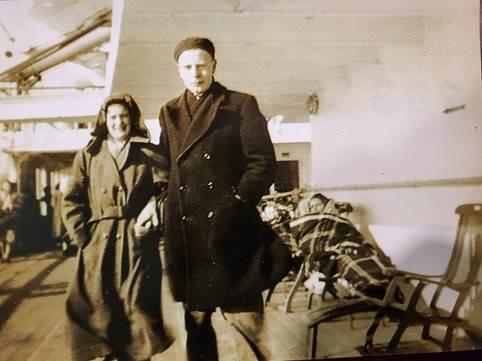Photo en tons sépia d’un homme et d’une femme néerlandais blancs portant de belles vestes sur le pont d’un bateau.